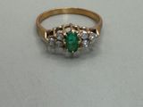 a close up of a gold ring with a green stone
