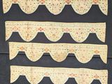 three pieces of cloth with scallops on them are hanging on a wall