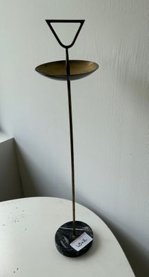 a small table with a candle holder on top of it next to a window