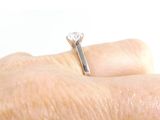 a woman ' s hand with a diamond ring on it