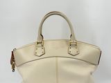 a white leather handbag with gold hardware on the handles