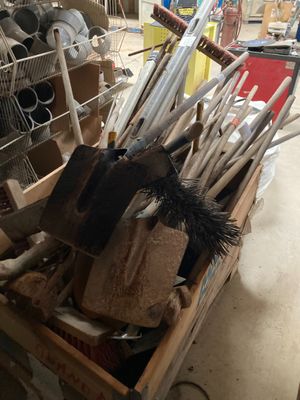 une caisse en bois remplie d'outils et un panier rempli de balais