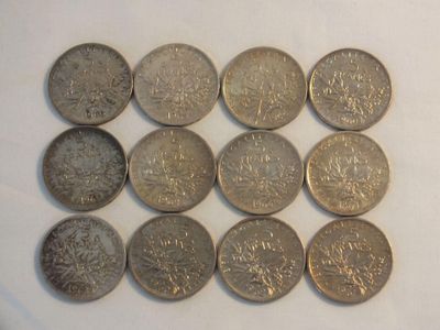 six different types of coins sitting on a white surface