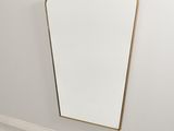 Le miroir est accroché au mur, dans un coin de la pièce.