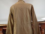 brown jacket on a mannequin stand in front of a white backdrop