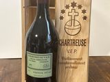 une bouteille de vin posée sur une table à côté d'une caisse en bois
