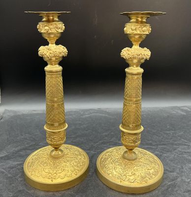 paire de bougeoirs anciens en laiton ornés de motifs floraux