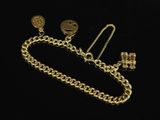 a close up of a gold chain with a pair of earrings on it