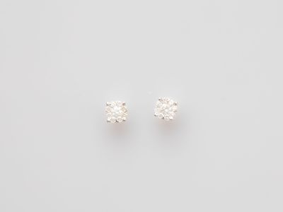 a pair of diamond stud earrings on a white background