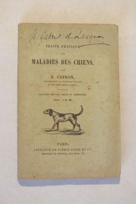 un vieux livre sur lequel figure un chien, posé sur une table
