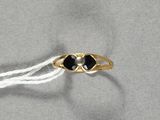 une bague en or sertie de deux pierres noires