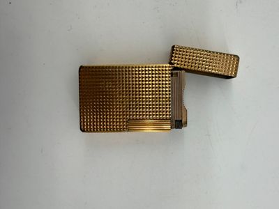 two gold colored lighters sitting next to each other on a white surface