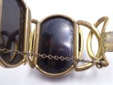 a close up of a bracelet with a black stone on it