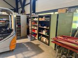 une photo d'un garage avec un chariot élévateur au milieu de la pièce