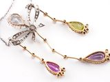 two necklaces with different colored stones and a bow on a white background