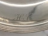 a silver plate that has a monogram on it