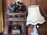 une petite table sur laquelle se trouvent une lampe et un vase