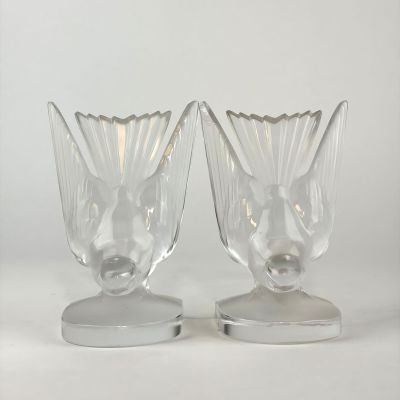 two clear glass vases sitting on top of a metal stand