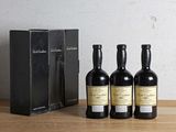 three bottles of wine sitting on a table next to a box of wine
