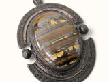 une photo d'une photo d'un pendentif serti d'une pierre