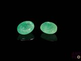 a pair of green jade earrings on a black surface