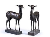 pair of bronze sculptures of a deer and a deer standing on a base