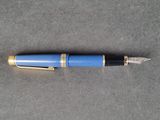 an image of a blue fountain pen on a gray surface