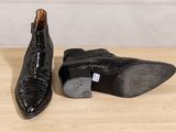 a pair of black shoes sitting on top of a wooden table