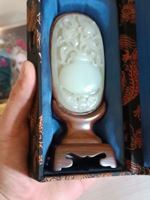 a person holding a box with a carved object in it