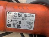 un gros plan d'une perceuse électrique rouge posée sur une table