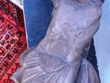 une statue représentant un homme allongé sur un tapis posé à même le sol