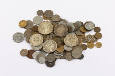 a pile of old coins on a white surface