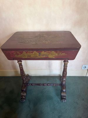 a small table with a wooden top and ornate carvings on it