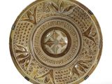 une assiette marron ornée de motifs sur un fond blanc