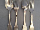 quatre cuillères en argent et deux cuillères en argent sur une table