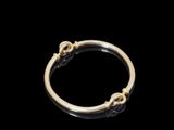 gros plan d'une bague en or sur fond noir