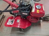 a small red machine that is sitting on the ground