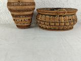 two woven baskets sitting on top of a table next to each other