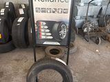 une enseigne d'un atelier de réparation de pneus avec des pneus posés par terre