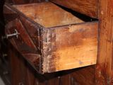 an old wooden drawer with a metal handle in a room
