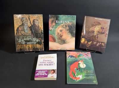 several books are sitting on a table with a black background