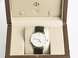 a box with a watch inside of it on a white surface