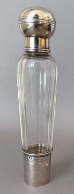 a small glass bottle with a silver lid on a table