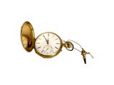 une montre de poche en or à laquelle est accrochée une clé sur le côté
