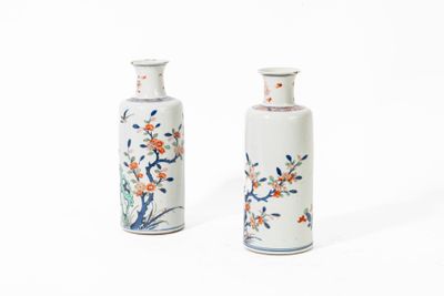 deux petits vases ornés de fleurs, posés sur une surface blanche