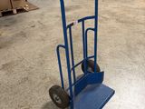 a blue hand truck that is sitting in a warehouse