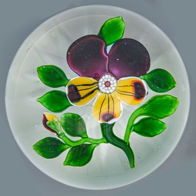 une assiette en verre ornée d'une fleur, posée sur une table