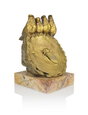three birds sitting on top of a gold clock on a marble base