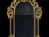 un miroir richement décoré, avec un fond noir et des bordures dorées