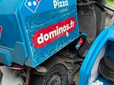 a pile of junk that has a blue and red dominos pizza truck on top of it